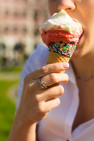 Young woman eats Ice cream cone in a parkの写真素材