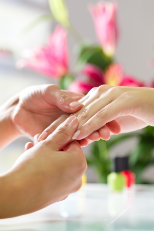 Woman in a nail salon receiving a manicure by a beautician, she is getting a hand massageの写真素材
