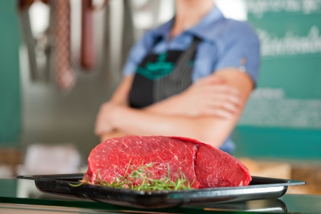 Closeup of delicious beef meat with female butcher in backgroundの写真素材