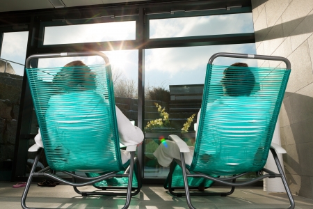 Young couple relaxing in wellness spa on liege, they enjoy the sunの写真素材