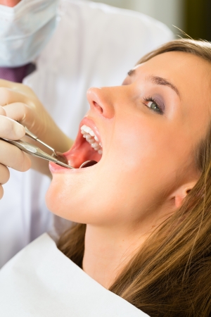 Female patient with dentist in a dental treatment, wearing masks and glovesの写真素材