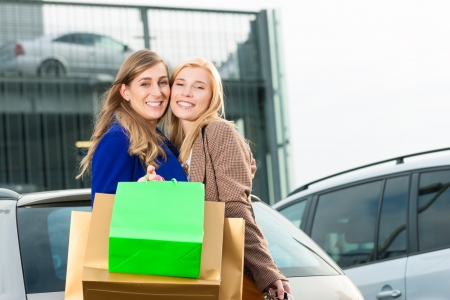 Two women were shopping in a mall or shopping centre and driving home now with their carの写真素材