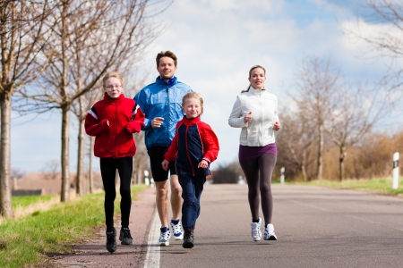 Family, mother, father and children are running or jogging for sport outdoorsの写真素材