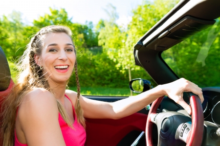 Young beautiful woman  with cabriolet convertible car in summer on a day tripの写真素材