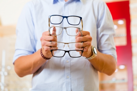Young man at optician with glasses, he might be customer or salespersonの写真素材