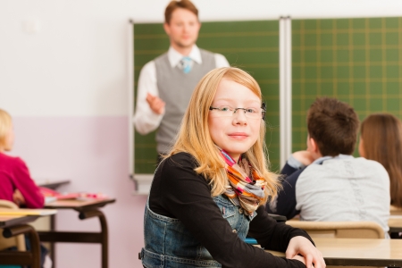 Education - Young teacher with pupil in his form of the elementary or primary school teachingの写真素材