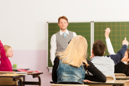 Education - Young teacher with pupil in his form of the elementary or primary school teachingの写真素材