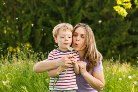 Family summer - blowing dandelion seeds の写真素材