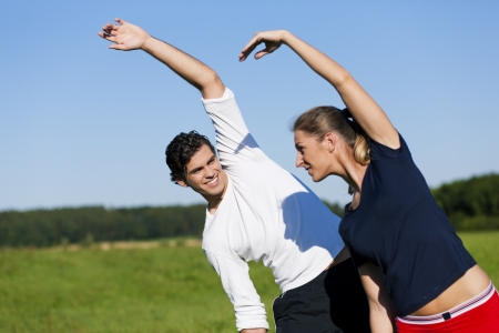 Couple warming up for exercise in summer の写真素材