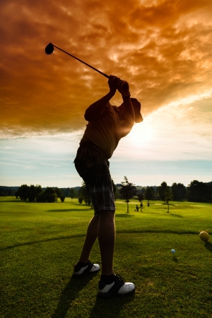 Young golf player on course doing golf swing, he presumably does exerciseの写真素材