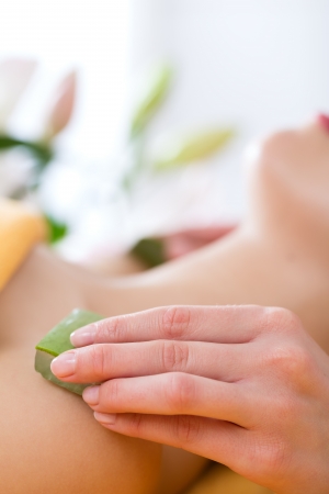 Wellness - woman receiving head or face massage whit aloe Vera in spaの写真素材
