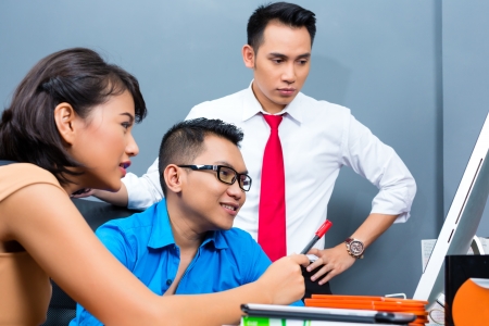 Asian Creative agency - team meeting in an office with laptopの写真素材