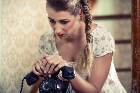 Woman sitting on the stairs waiting for a call and looking unhappyの写真素材