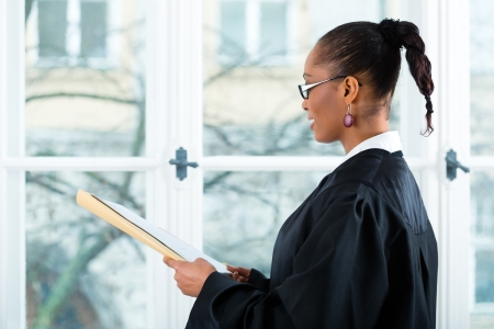 Young female lawyer working in her office with a file or dossierの写真素材
