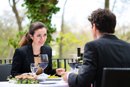 Businesspeople having business lunch outside on the terrace in a fine dining restaurantの写真素材