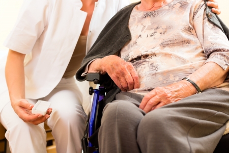 Young nurse and female senior in nursing home, the old lady sitting in a wheel chairの写真素材