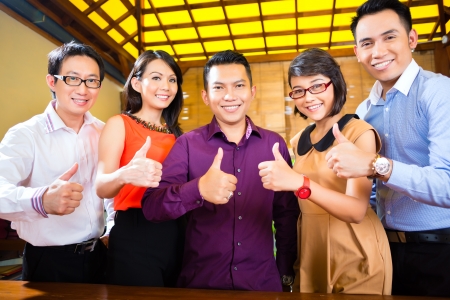 Asian Creative agency - businesspeople in office, its a good and young team, thumbs upの写真素材
