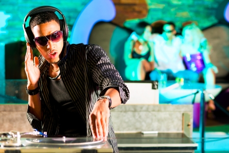 Black DJ in a club at the turntableの写真素材