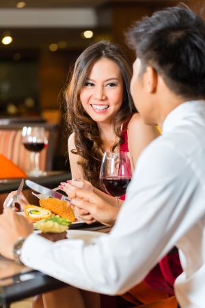 Asian Chinese couple - Man and woman - or lovers flirting and having a date or romantic dinner in a fancy restaurant Asian Chinese couple - Man and woman - or lovers flirting and having a date or romantic dinner in a fancy restaurant