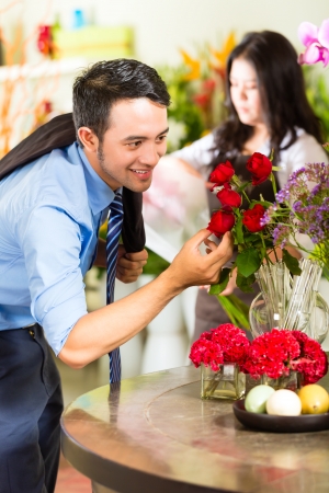 Young Asian or Indonesian Man is interested for a bouquet Rosesの写真素材