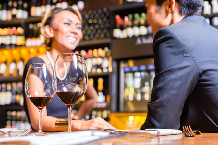 Asian Couple chatting in a wine shopの写真素材