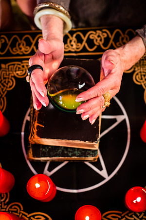 Female Fortuneteller or esoteric Oracle, sees in the future by looking into their crystal ball during a Seance to interpret them and to answer questionsの写真素材