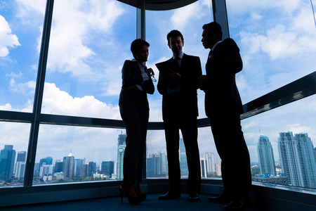 Businesspeople standing in modern officeの写真素材