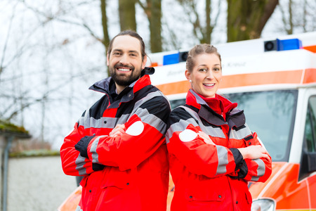 Emergency doctor and nurse standing in front of ambulance carの写真素材