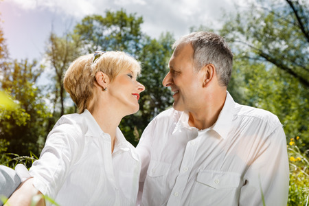 Senior couple sitting on beautiful spring day in loveの写真素材