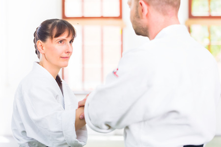 Man and woman fighting at Aikido training in martial arts school の写真素材