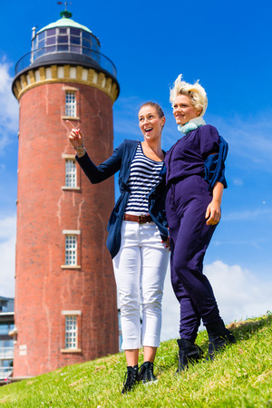 Woman enjoying vacation at German north sea coast lighthouse の写真素材