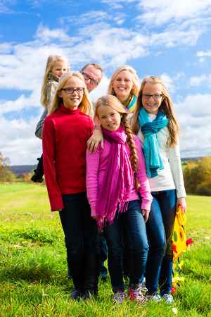Family walking through the park in fall or autumnの写真素材