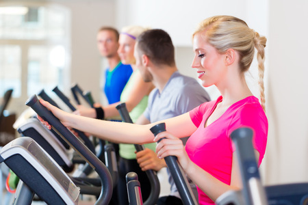 Group of fitness people in sport gym on treadmill