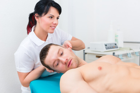 Patient at the physiotherapy getting spine set from therapistの写真素材