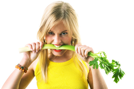 Food and healthy nutrition - Woman eating a celery very aggressivelyの写真素材