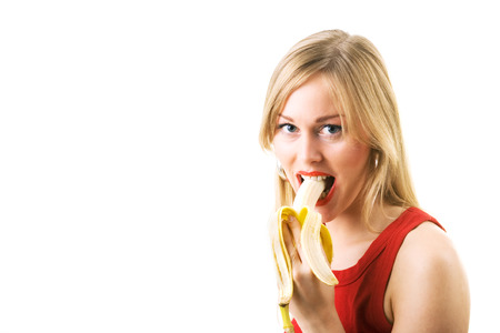 Sweet blond girl eating a bananaの写真素材