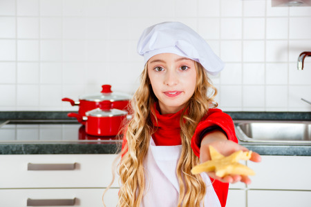 Child baking Christmas cookies at home in domestic kitchenの写真素材