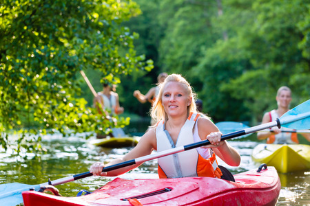 woman with kayak or canoe on forest riverの写真素材