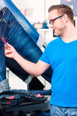 Man shopping jeans in fashion storeの写真素材
