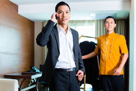 Portrait of guest and bell boy in hotel roomの写真素材