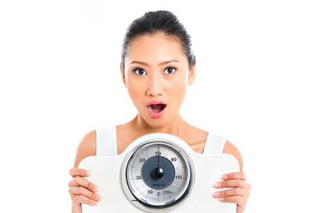 Asian woman with weight scale losing weightの写真素材