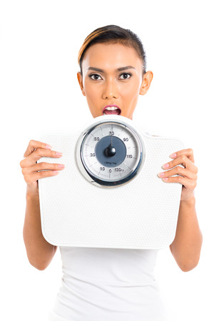 Asian woman with weight scale loosing weightの写真素材
