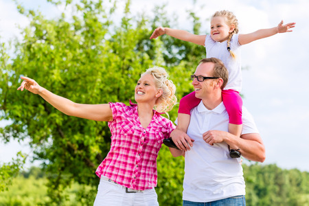 Family having summer walk on meadow outdoorsの写真素材