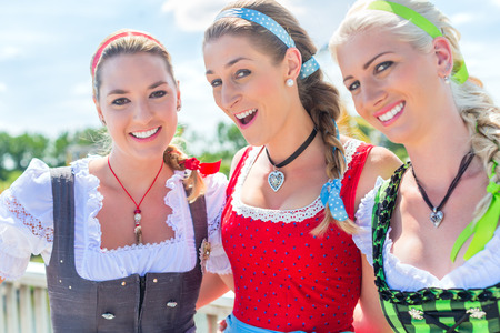 Friends visiting together Bavarian fair in national costume or Dirndlの写真素材