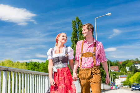 Couple visiting together Bavarian fair in national costume leather pants and Dirndlの写真素材