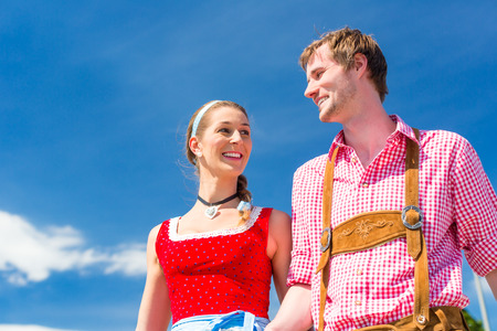 Couple visiting together Bavarian fair in national costume leather pants and Dirndlの写真素材