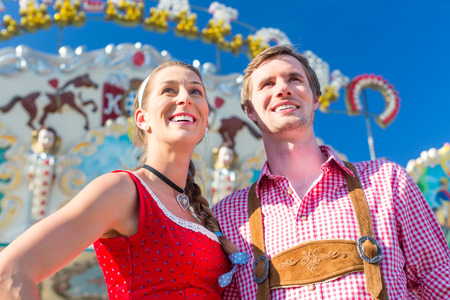 Couple visiting together Bavarian fair in national costume leather pants and Dirndlの写真素材