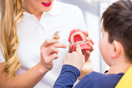 Female Orthodontist explaining boy braces