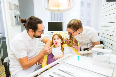 Dentist giving girl treatment  in dental surgeryの写真素材