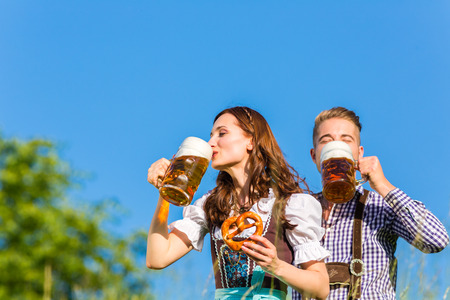German couple in Tracht with beer and pretzelの写真素材